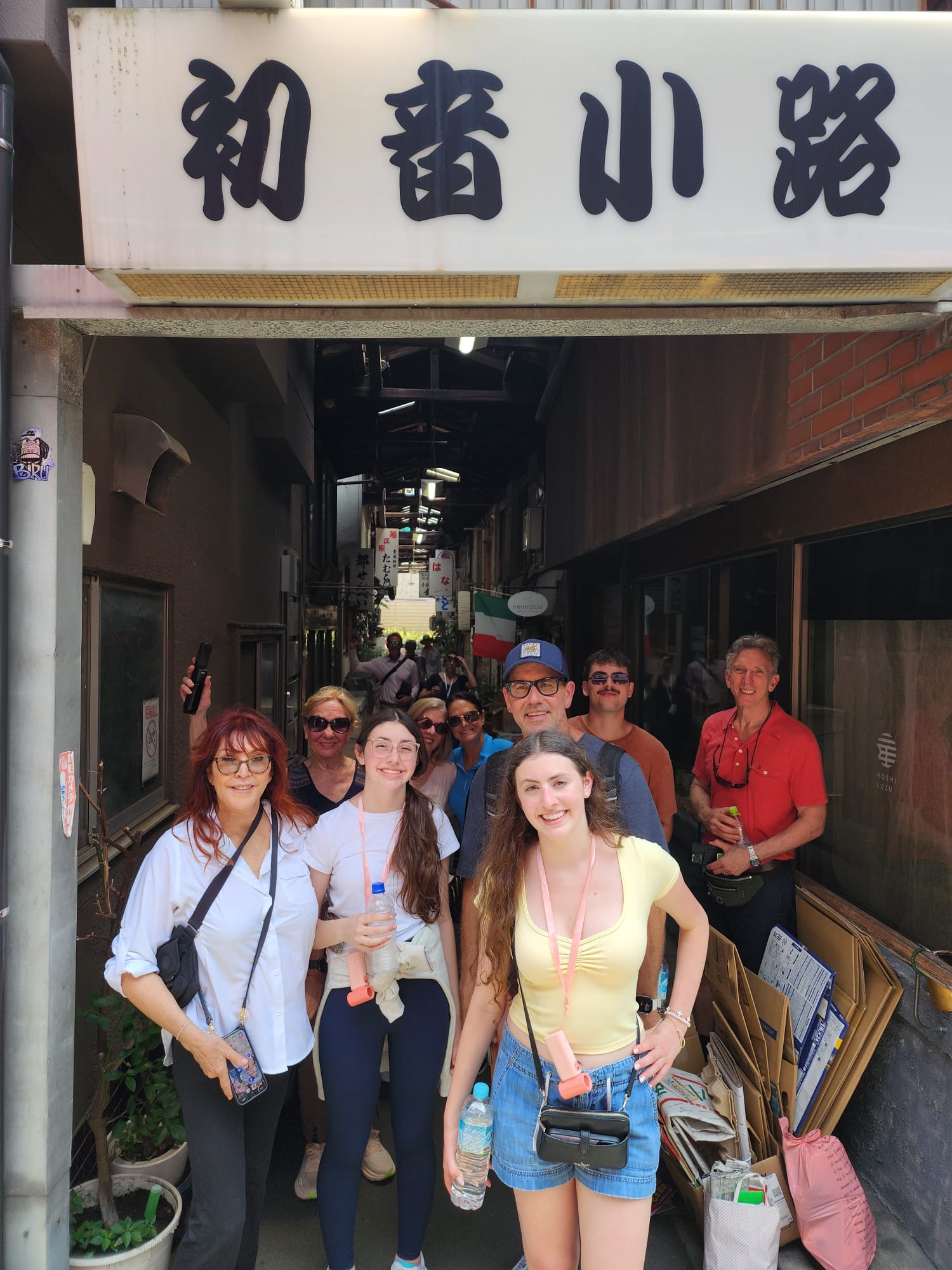 Group posing by sake barrel wall at Meiji Jingu