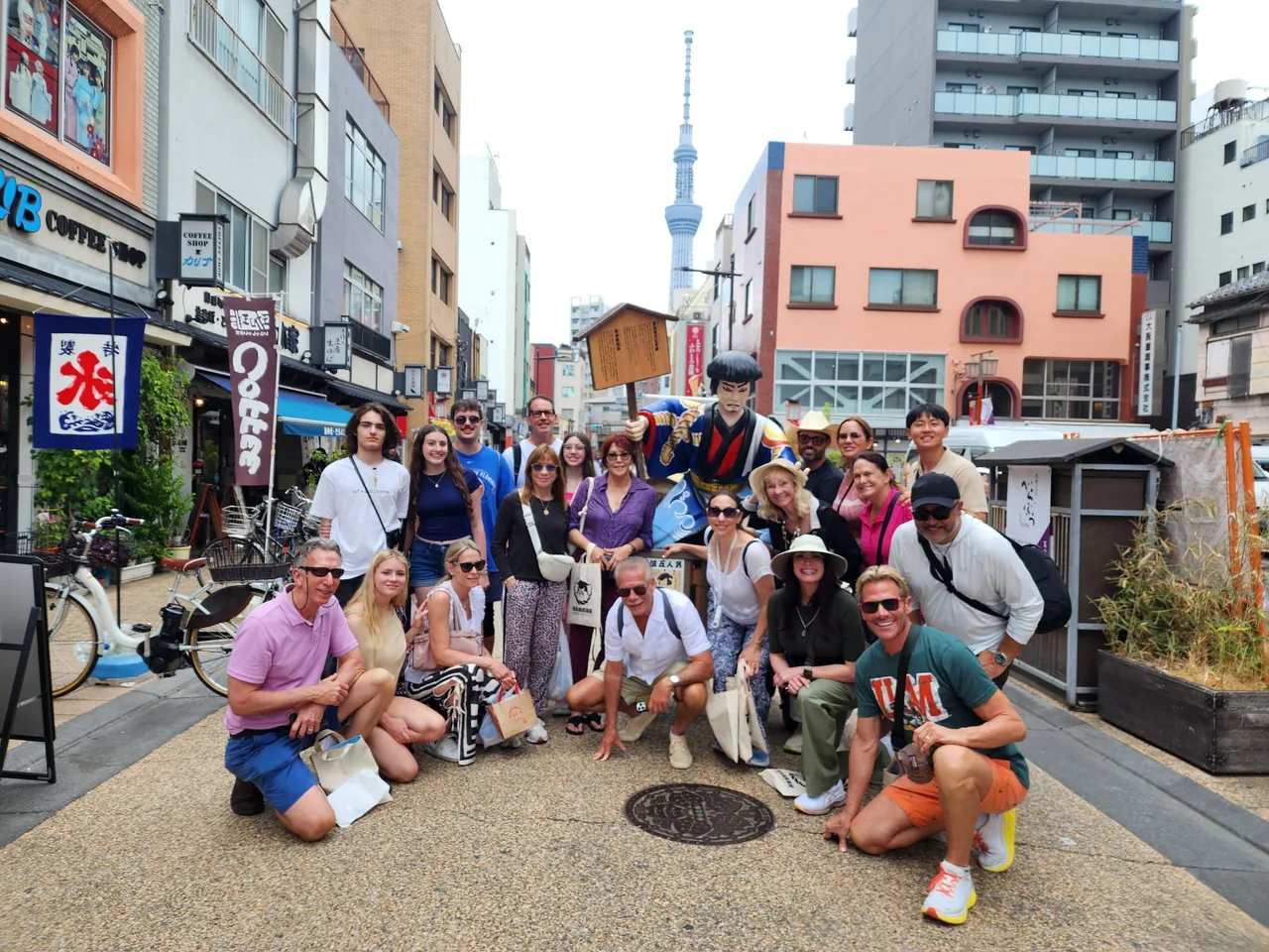 Tour guests posing on a city street with a tall tower in the background