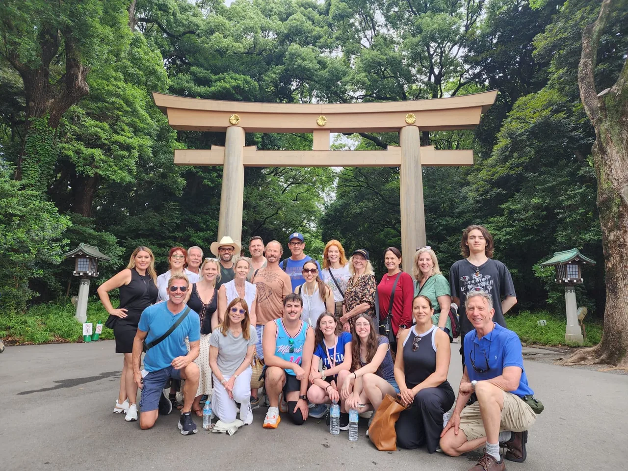 Tour guests posing in front of a torii gate surrounded by trees